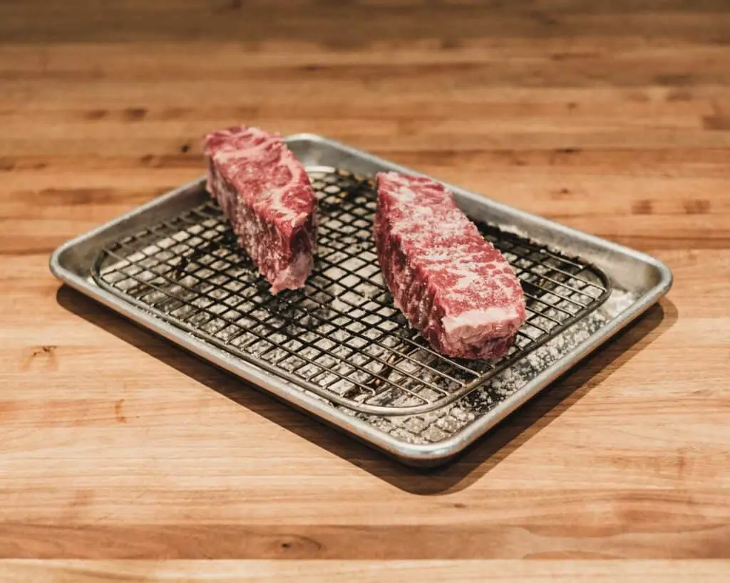 Two small pieces of wagyu beef on a pan
