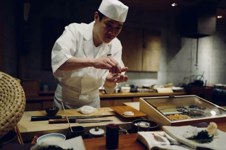 A sushi chef using spices