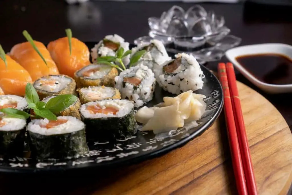 Neatly plated sushi rolls with chopsticks right next to them