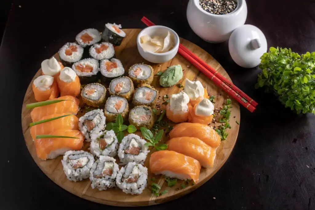 A plate full of sushi rolls, sashimi, and nigiri