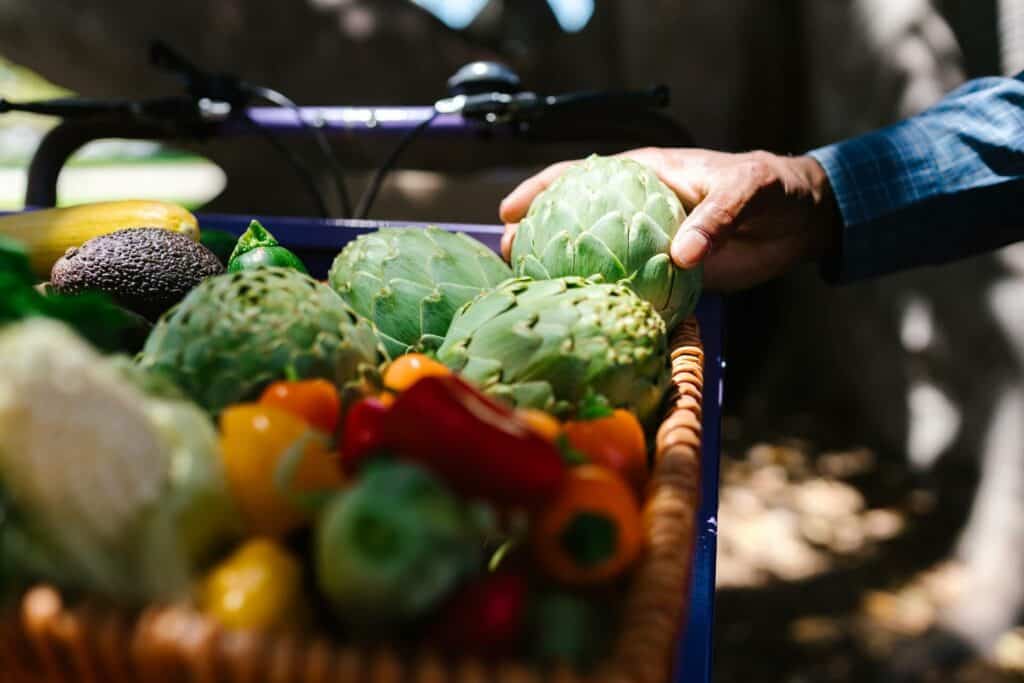 Person holding a green artichoke