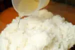 A person mixing vinegar and rice