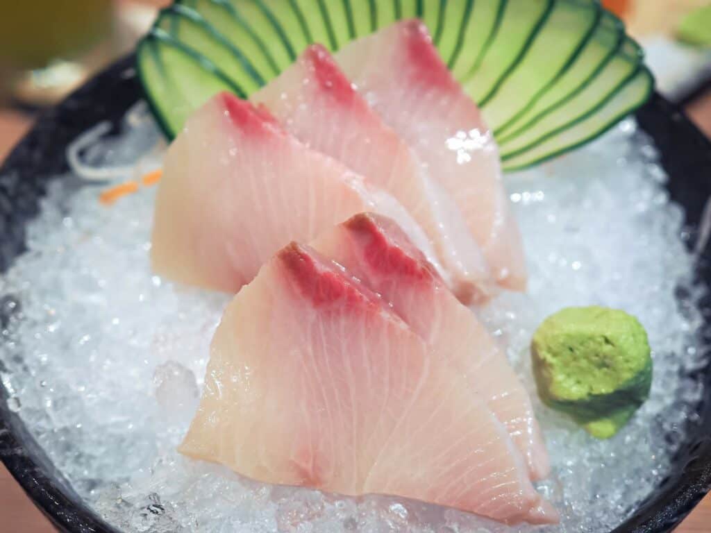 Hamachi sashimi in a black bowl