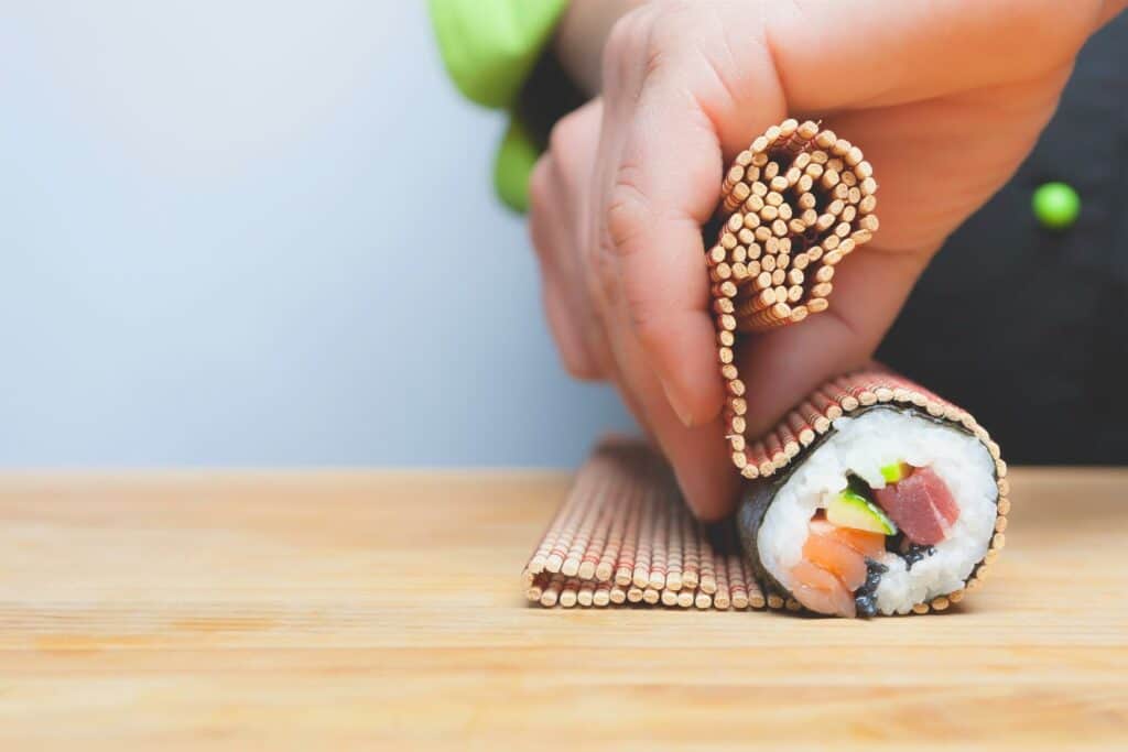 Person making a sushi roll