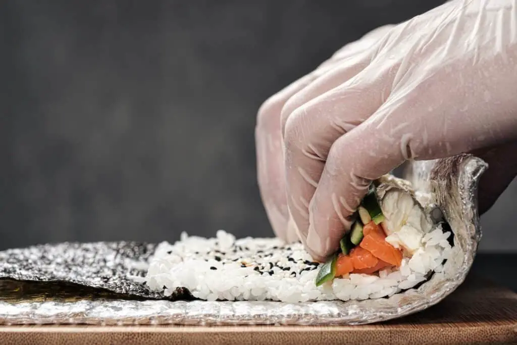 Person making a sushi roll