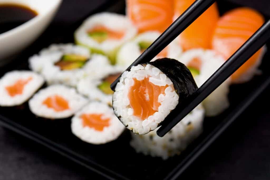 Makizushi held with black chopsticks