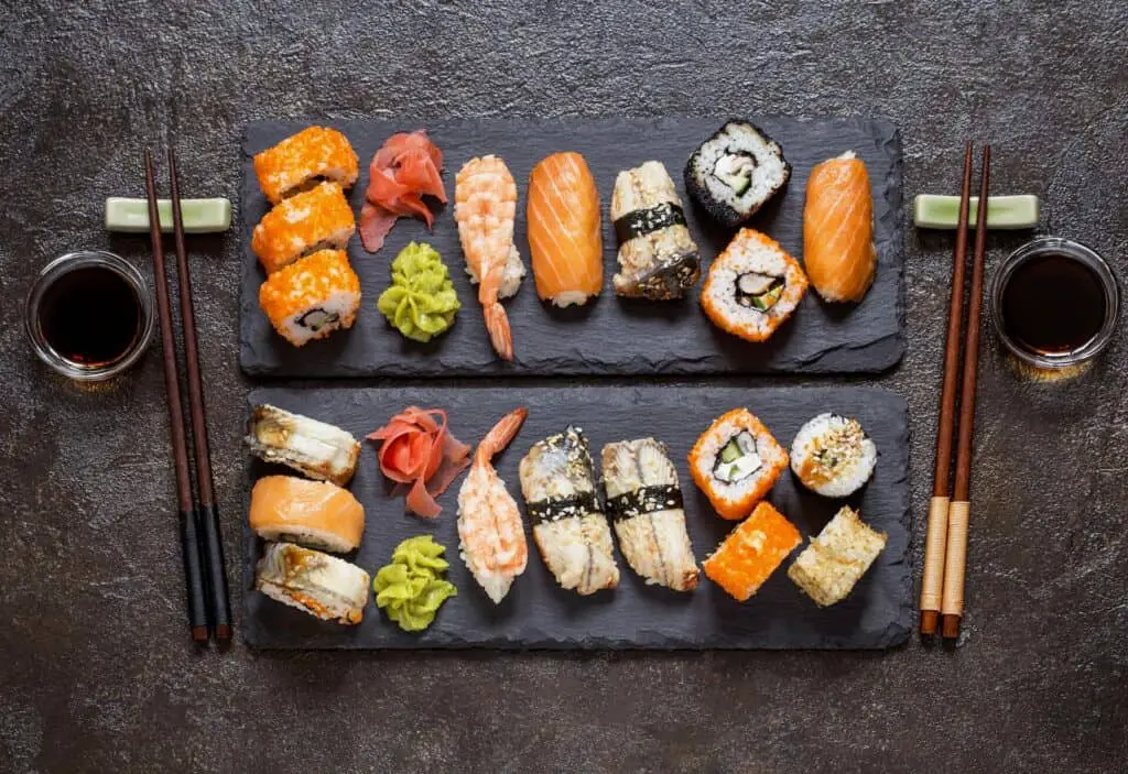 Two portions of sushi on a black stone plate