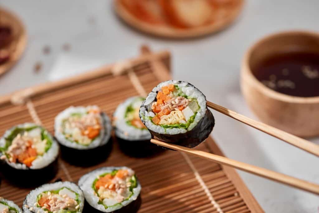 Maki roll held above other rolls with chopsticks