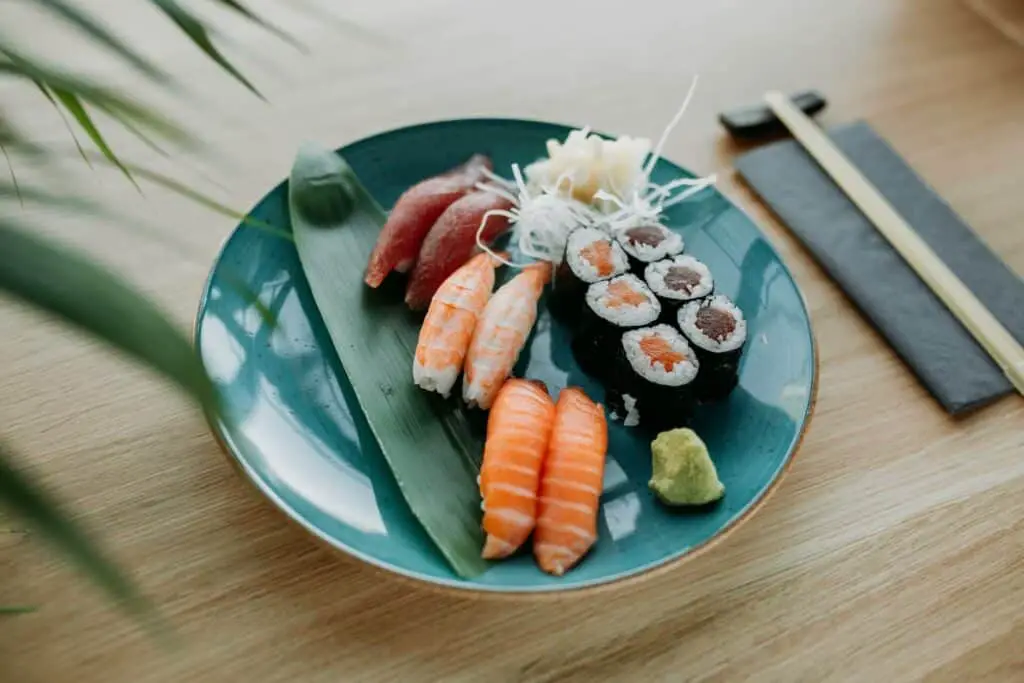 Sushi on a blue plate, chopsticks on the right