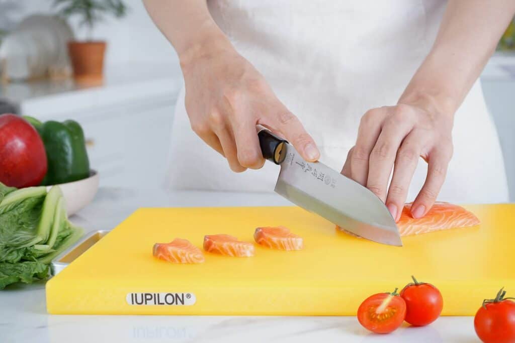 A person cutting raw fish