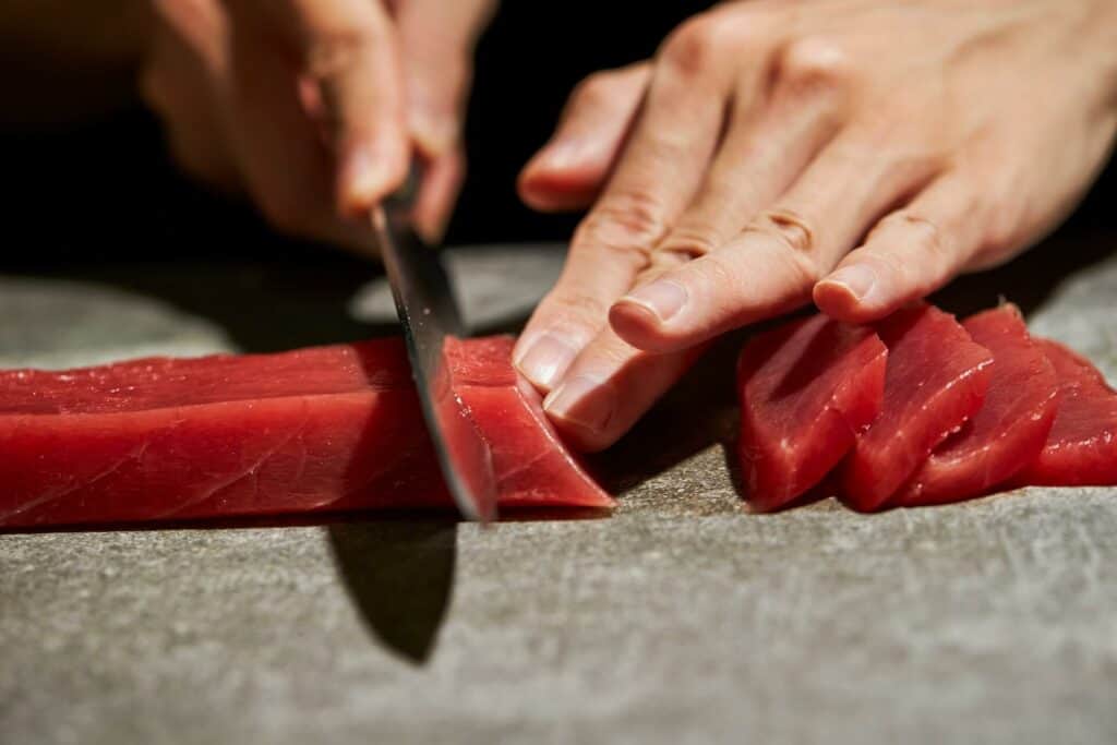 Person slicing raw tuna