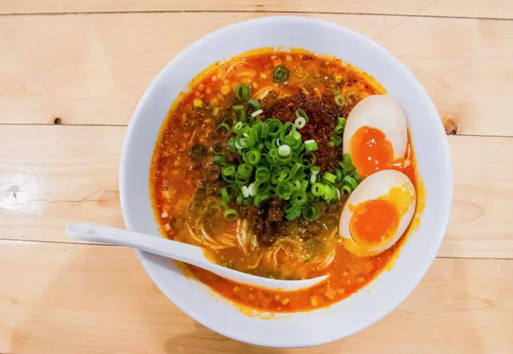 Ramen in a bowl with boiled eggs and sliced leek