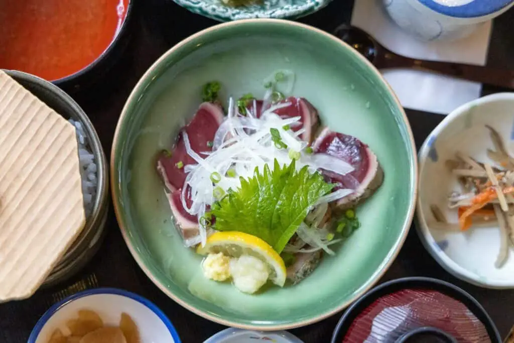 Sashimi plate garnished with shiso leaves and daikon radish