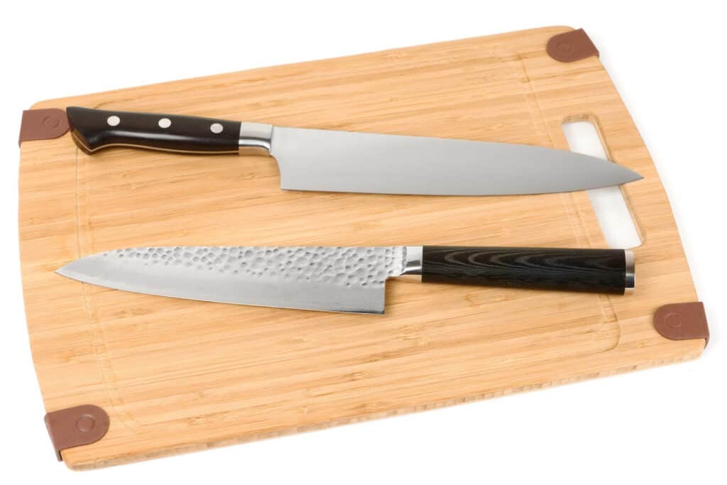 Two knives on a wooden cutting board
