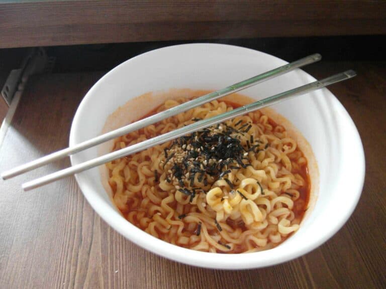 A bowl of hot spicy noodles and chopsticks over it