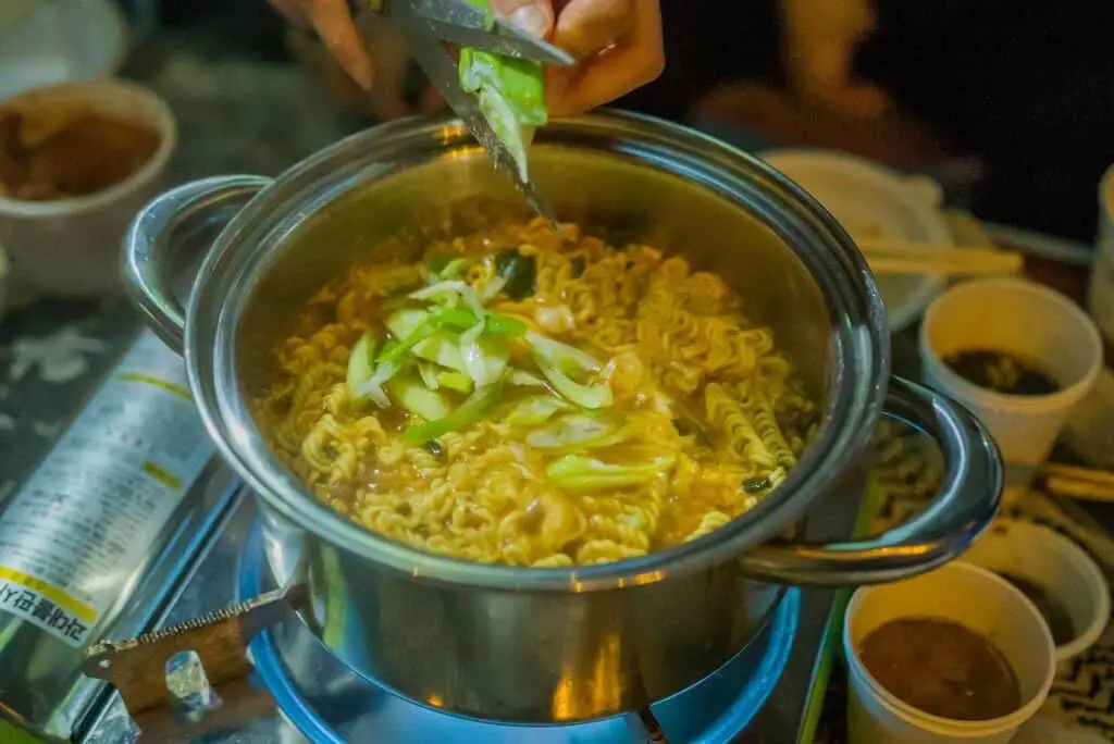 Instant noodles in a pot with vegetables