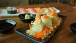 A shrimp tempura roll served on a white plate