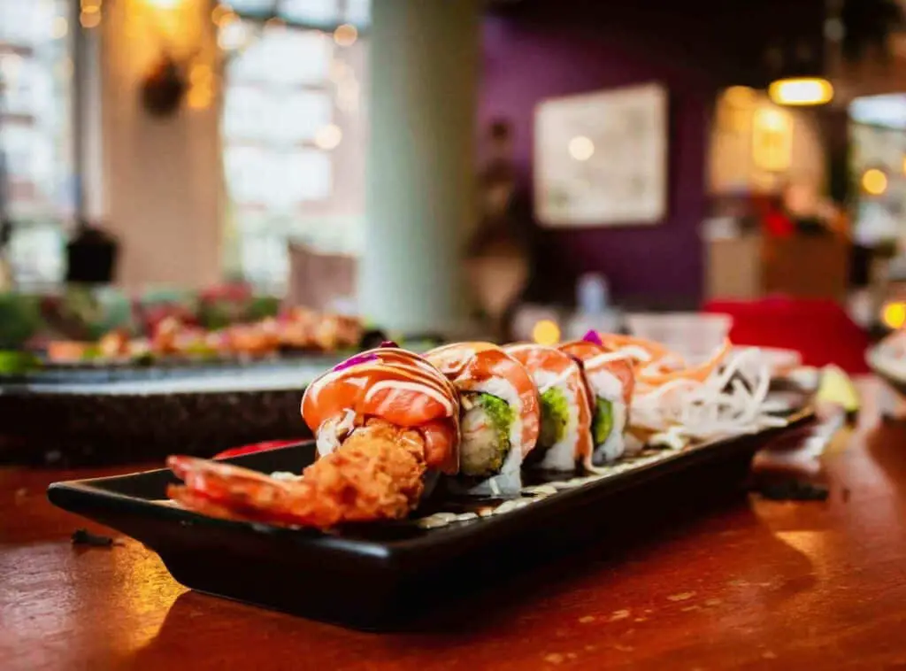 A shrimp tempura roll cut up on a plate