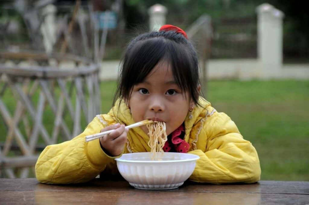 Girl eating instant ramen noodles