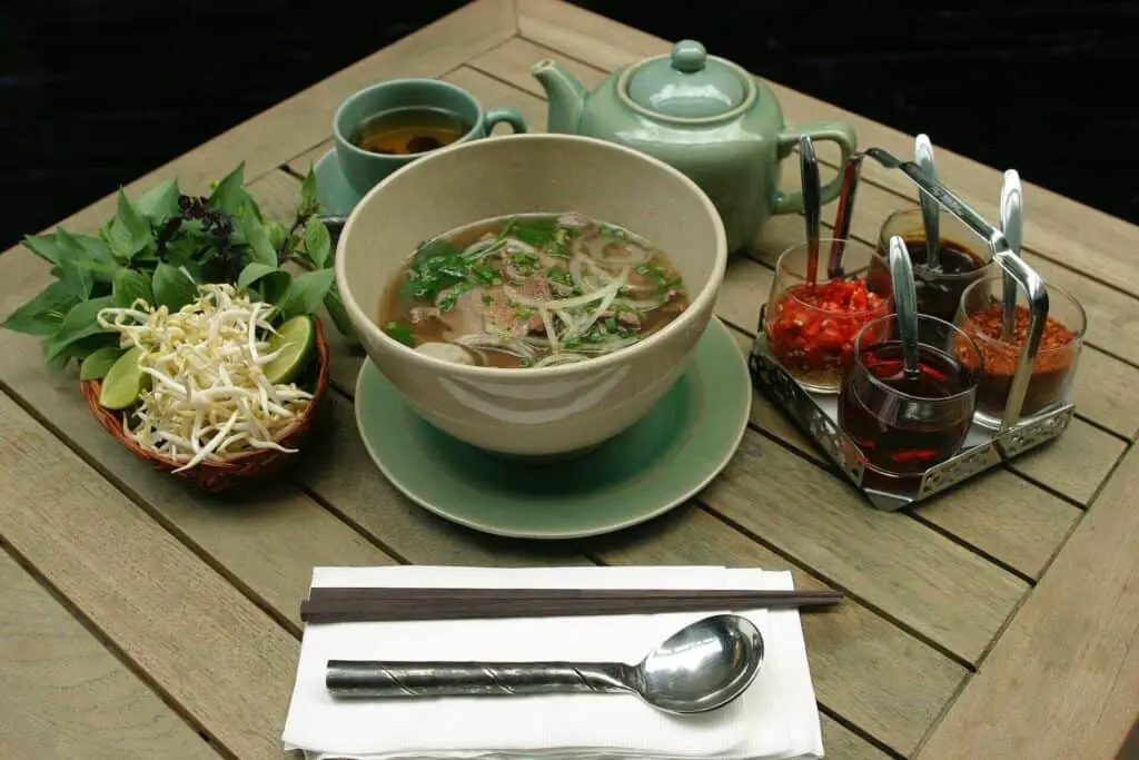 Miso soup in the middle of a table with various vegetables around