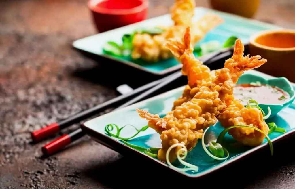 Shrimp tempura and a little bowl with sauce on the plate 