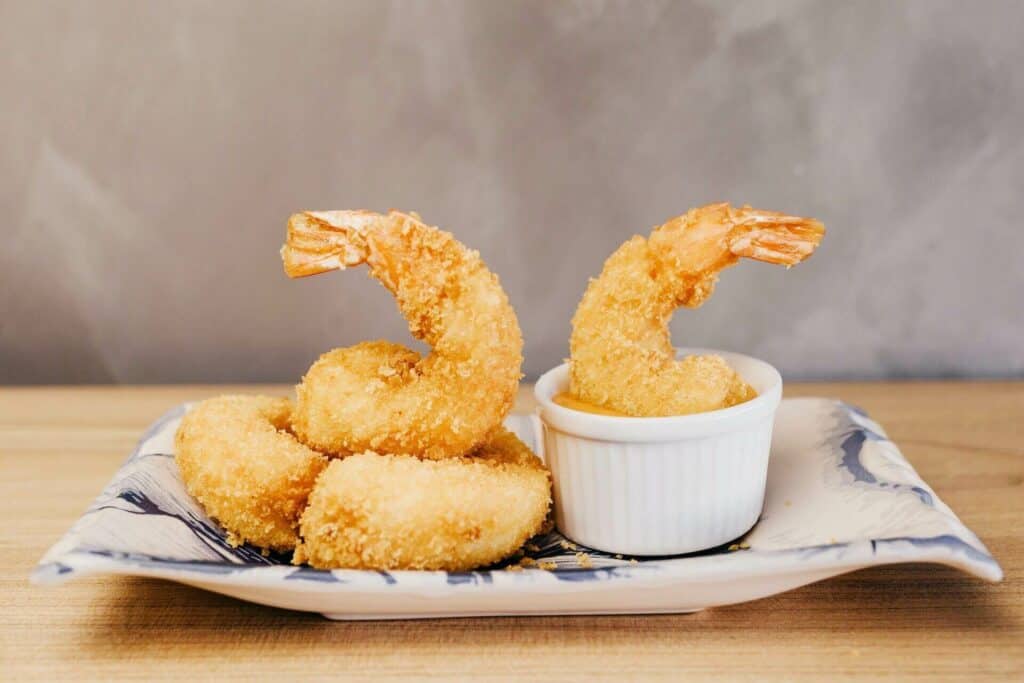 Some pieces of shrimp tempura in sauce