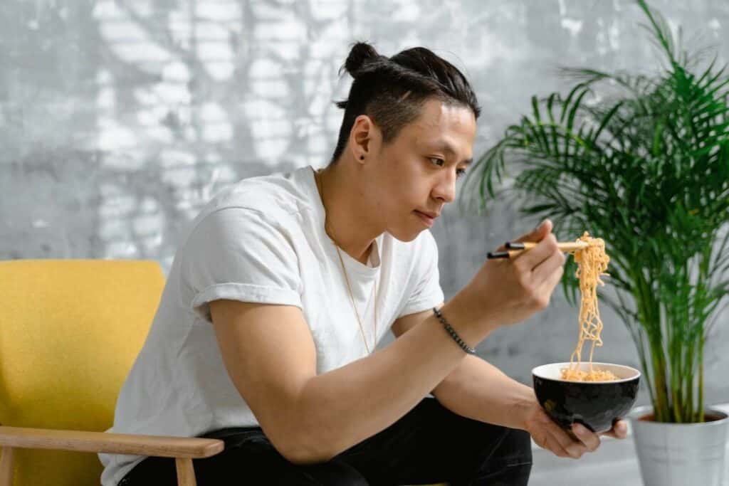 A man lovingly eating instant ramen